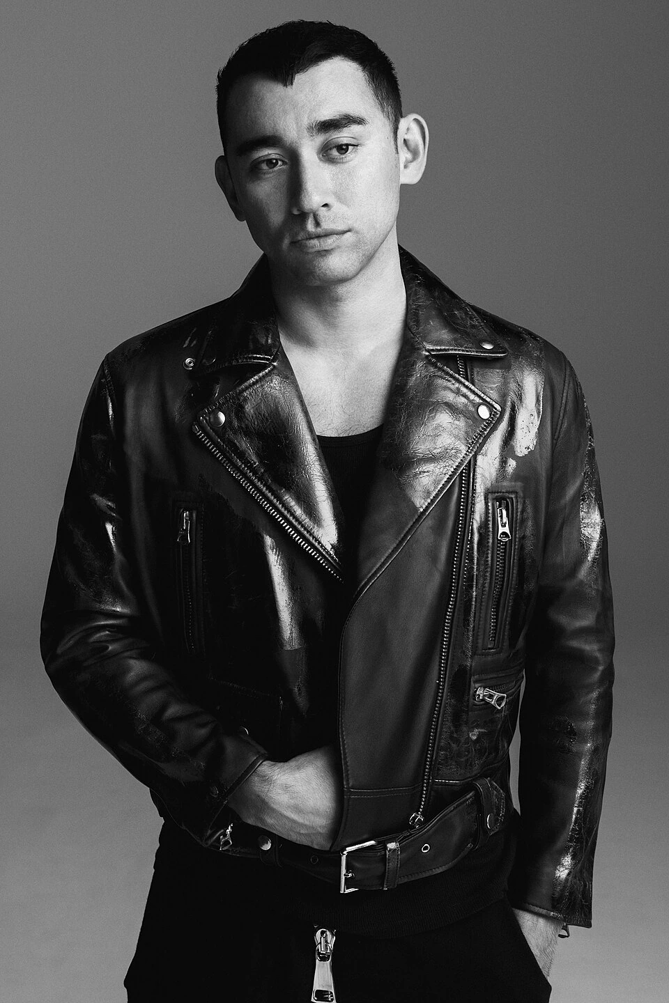 Black-and-white studio portrait of Nicola Formichetti wearing a leather jacket.